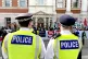 Police look on as protesters gather outside the Business and