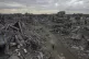 People walk amidst the destruction caused by the Israeli air