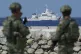Philippine troops watch a Philippine coast guard ship as the