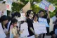 People hold signs during the press conference outside of the