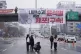 A banner is displayed on the overpass during a rally demandi