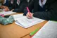 Students writing in their exercise books