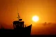 The sun rising behind fishing boats on the beach in Dungenes