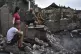 A couple sit in front of their house destroyed by a Russian 