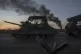 Ukrainian servicemen ride atop on a tank after returning fro