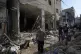 Palestinians examine the damage following an Israeli airstri
