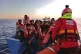 An SMH rescuer attends to people onboard a wooden boat