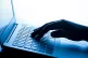 A woman's hand pressing keys of a laptop keyboard
