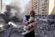 A housing block is reduced to burning rubble by an Israeli a