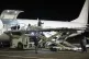 Workers remove coffins of victims from a plane after the Aze