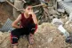 12-year old Abdulrahman, seated on the rubble of his home, w