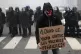 A man holds a sign reading 