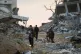 REMNANTS: Palestinians walk along a street in Gaza City, lit