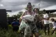 A woman carries her child after receiving a food donation fr