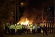 Riot police at the scene as a police van goes up in flames o