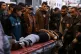 People watch medics while move a wounded youth, who was shot