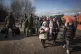 Women and children arrive at a makeshift camp to board a tra