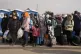 People fleeing from Ukraine queue to board on a bus at the b