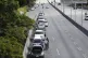 Men stand alongside vehicles lined up to enter a petrol stat